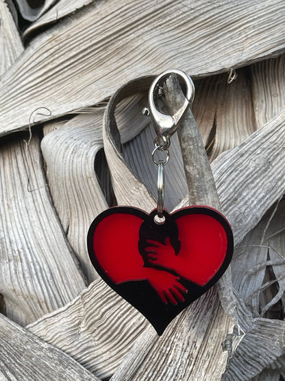 a red heart shaped keychain hanging from a hook