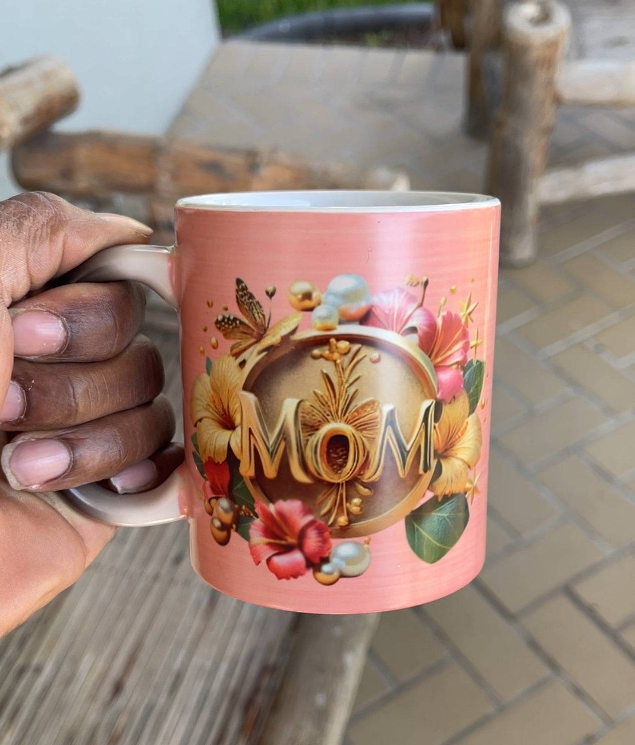 a person holding a coffee mug with a picture saying mom on it