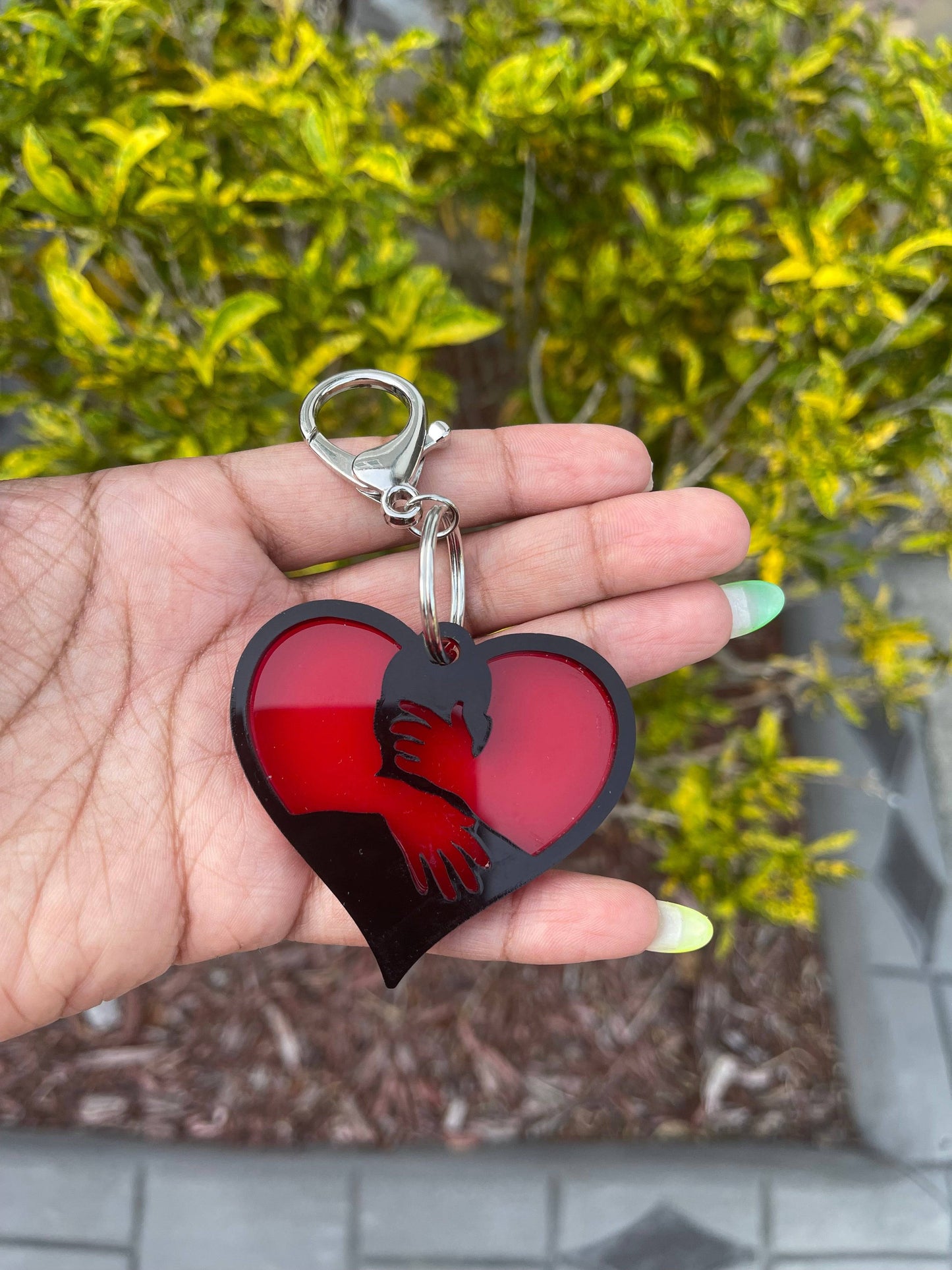 a hand holding a heart shaped key chain