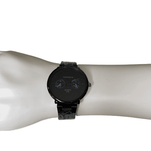 a black watch on a white wrist on a white mannequin