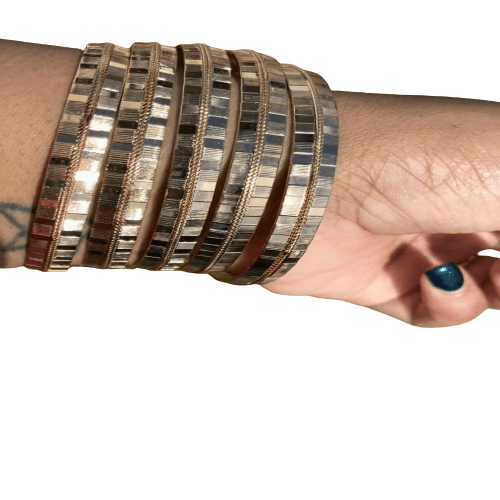 a woman's arm with a stack of bracelets on it