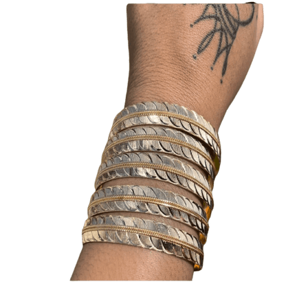 a woman's arm with a bunch of bracelets on it