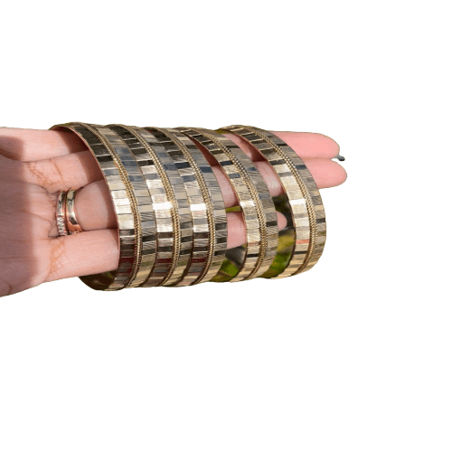 a hand holding a stack of gold bracelets