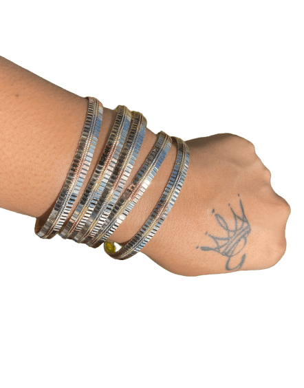 a woman's arm with a stack of bracelets on it