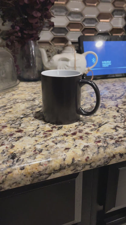 a black coffee mug sitting on top of a counter