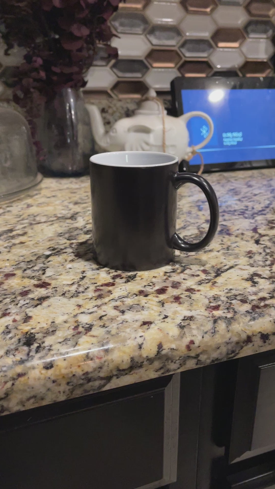 a black coffee mug sitting on top of a counter