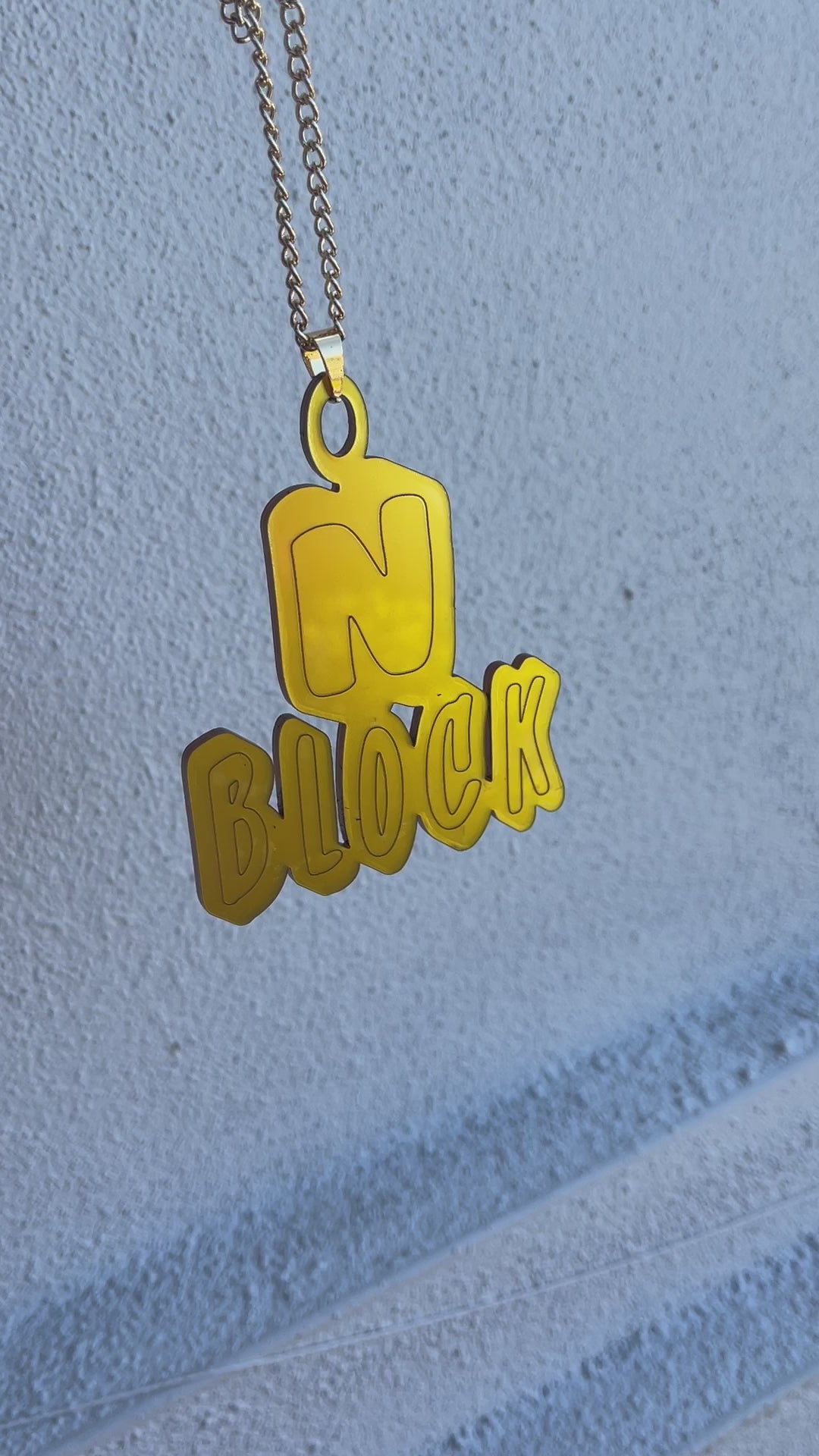 a yellow necklace with a custom charm hanging